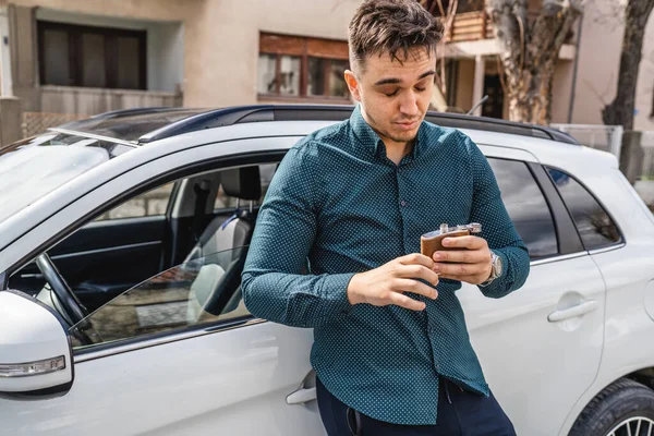 車の前に立って酒を飲んでる男が一人 — ストック写真