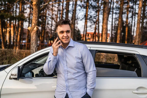 사업가는 자동차 야외에서 전화를 사용하며 통화를 있는데 셔츠를 바쁘게 일하는 — 스톡 사진