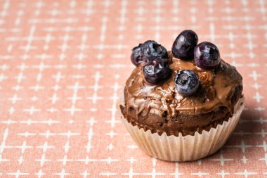 Masanın üzerinde çikolatalı kremalı ve yaban mersinli taze kek.