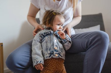 Küçük beyaz bir kız çocuğu, annesinin giydirdiği ya da giydirdiği küçük kızı, çocukluk döneminde evde giydirdiği ve büyüdüğü aile kavramı olan gerçek insanlar mekanı kopyalıyor.