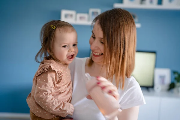 Small Caucasian Baby Girl Drinking Water Bottle Hands Her Mother — Stockfoto