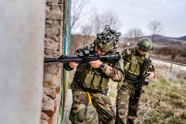 Üniformalı iki asker eve zorla giriyorlar. Operasyon sırasında harabeye dönüyorlar. Savaş köpekleri.