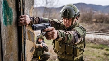 Üniformalı iki asker eve zorla giriyorlar. Operasyon sırasında harabeye dönüyorlar. Savaş köpekleri.