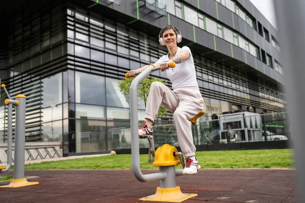 Günümüzde, spor salonunda bisiklet eğitmeni simülatöründe kısa saç eğitimi alan, modern, olgun, beyaz bir kadın spor salonu sağlıklı yaşam tarzı konseptini taklit ediyor.