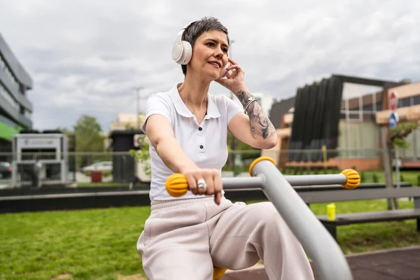 Günümüzde, spor salonunda bisiklet eğitmeni simülatöründe kısa saç eğitimi alan, modern, olgun, beyaz bir kadın spor salonu sağlıklı yaşam tarzı konseptini taklit ediyor.