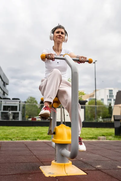 Günümüzde Spor Salonunda Bisiklet Eğitmeni Simülatöründe Kısa Saç Eğitimi Alan — Stok fotoğraf