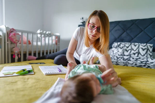 白人妇女年轻母亲在家里的床上照顾她的新生儿真正的人现代母亲的概念 — 图库照片