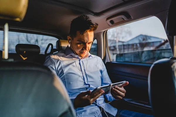 車の後部座席に座っている1人の若い大人のCucasianマネージャーかビジネスディレクタービジネスの実際の人々のコピースペースを配置するためにデジタルタブレットを使用してオンライン電話会議を持っている間 — ストック写真