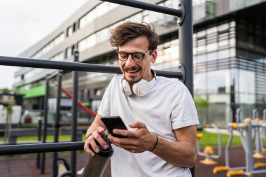 Beyaz bir adam açık hava spor salonunda çalışırken fren yapıyor cep telefonuyla mesajlaşıyor ya da okuyor barlarda elinde takviye titretici, elinde mutlu bir gülümseme fotokopi alanı ile dinleniyor.