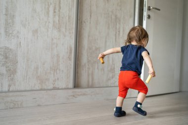 Küçük bir beyaz çocuğun ya da bir kızın el ele tutuşup oyuncaklarını tutarak uyanması çocukluk gelişimi ve büyüme konseptini taklit ediyor.