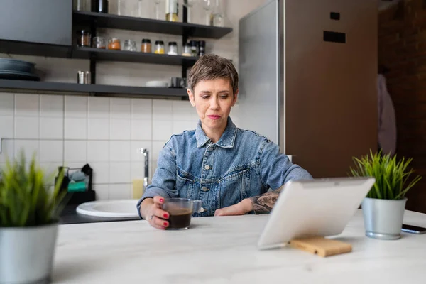 Yetişkin Bir Kadın Mutfakta Kahve Içerken Dijital Tablet Kullanıyor Günlük — Stok fotoğraf