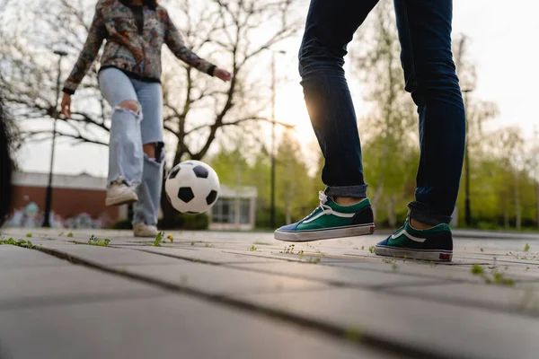 男と女の足カップルは 舗装上の町や都市でボールを蹴ってサッカー屋外のカップルの男性と女性を果たしている — ストック写真