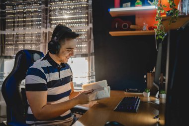 İnternet dersi sırasında bilgisayar başında karanlık bir odada oturup rehber ya da özel öğretmen olarak internetten eğitim alan beyaz bir genç adam gerçek insanlar.