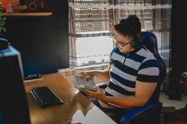 İnternet dersi sırasında bilgisayar başında karanlık bir odada oturup rehber ya da özel öğretmen olarak internetten eğitim alan beyaz bir genç adam gerçek insanlar.