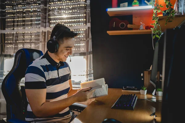 İnternet dersi sırasında bilgisayar başında karanlık bir odada oturup rehber ya da özel öğretmen olarak internetten eğitim alan beyaz bir genç adam gerçek insanlar.