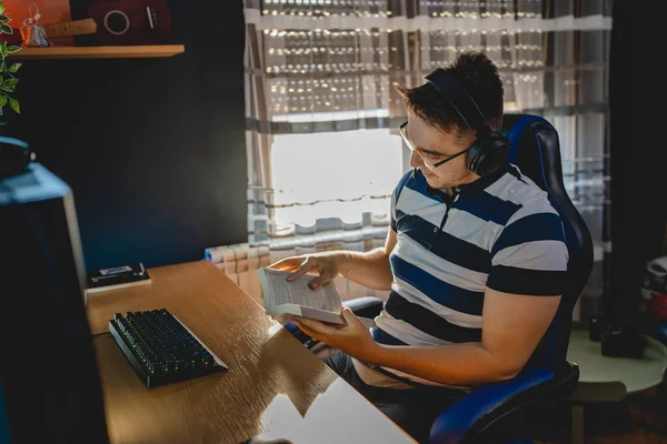 İnternet dersi sırasında bilgisayar başında karanlık bir odada oturup rehber ya da özel öğretmen olarak internetten eğitim alan beyaz bir genç adam gerçek insanlar.