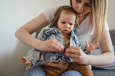 Küçük beyaz bir kız çocuğu, annesinin giydirdiği ya da giydirdiği küçük kızı, çocukluk döneminde evde giydirdiği ve büyüdüğü aile kavramı olan gerçek insanlar mekanı kopyalıyor.