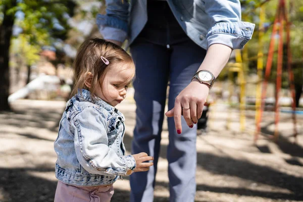 一人の赤ちゃん小さいCaucasian子供女の子で公園で彼女の母親保持手で遊びながら 明るい春の日に本当の人々子供時代の開発学習と家族の概念コピースペース — ストック写真
