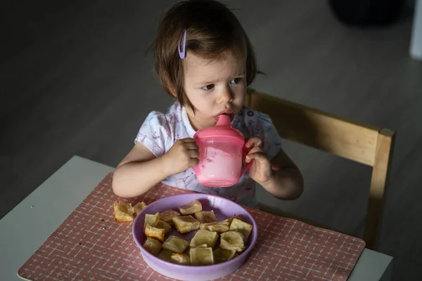 一人で家のテーブルに座っている一人の女の子の小さな白人の子供は 一日に一人で朝食やランチの食事を飲むヨーグルトを食べる開発コンセプトコピースペースを成長現実の人々 — ストック写真