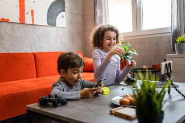 Erkek ve kız kardeş iki kardeş cep telefonuyla video blogu yapıyorlar evlerinden internet günlüğü için en sevdikleri oyuncak eleştirisi hakkında sosyal ağ kopyalama alanı için içerik oluştur ve paylaş