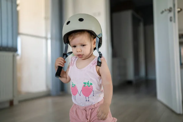 フロントビューポートレートの1人の女の子小さいCaucasian幼児赤ちゃん身に着けている保護ヘルメット頭の上に立っているか 部屋の中で家に歩いて新しいスキルを学ぶ早い開発コンセプト — ストック写真