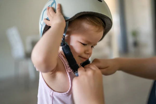 フロントビューポートレートの1人の女の子小さいCaucasian幼児赤ちゃんとお母さん上の着用保護ヘルメット上の頭の上に自宅で部屋で成長新しいスキル早期開発コンセプト — ストック写真