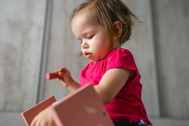 Küçük beyaz bir çocuk. Küçük beyaz bir kız. Çocukluğunda eğitici oyuncaklarla oynayan ve büyüyen erken gelişim konsepti.