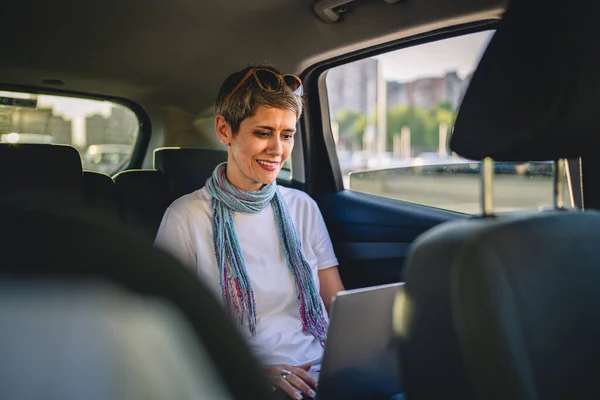 One Mature Woman Caucasian Female Sitting Back Seat Car Working — 스톡 사진