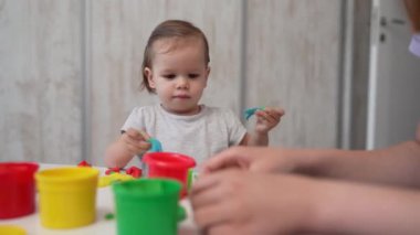 Bir küçük beyaz çocuk, çocukluğunda renkli plastiklerle oynuyor ve gelişim konsepti geliştiriyor. 
