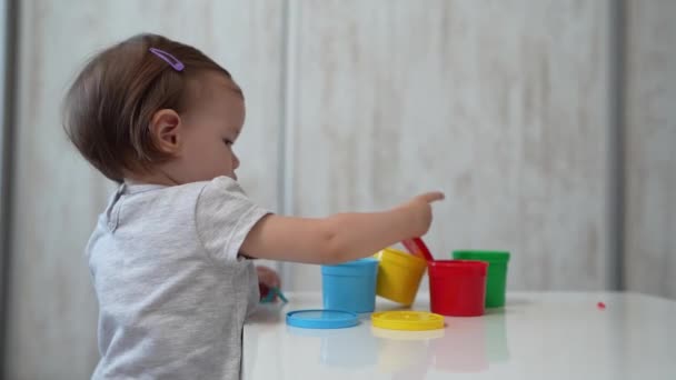 Egy Kislány Kis Kaukázusi Kisgyermek Játszik Színes Műanyag Asztalon Otthon — Stock videók