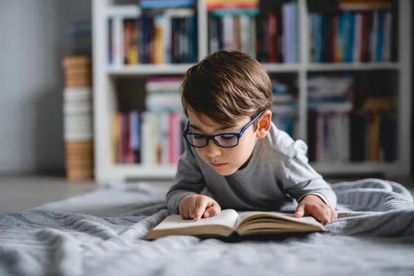 Kaukasiska Pojke Som Ligger Golvet Hemma Dagen Läser Bok Framifrån — Stockfoto