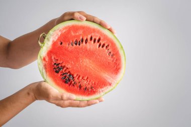 Bilinmeyen Kafkasyalı bir kadının elindeki karpuzun yarısı beyaz duvar arkasında fotokopi odasının önünde duruyor.