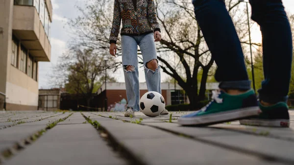 男と女の足カップルは 舗装上の町や都市でボールを蹴ってサッカー屋外のカップルの男性と女性を果たしている — ストック写真