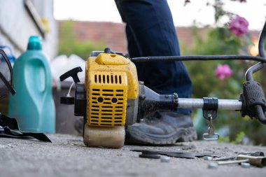 The gasoline lawn mower string trimmer brushcutter on the ground