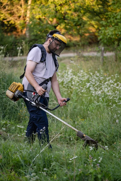 Young Caucasian Man Farmer Gardener Standing Field String Trimmer Petrol — Stockfoto