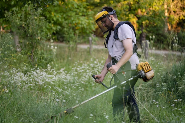 Young Caucasian Man Farmer Gardener Standing Field String Trimmer Petrol — Stockfoto