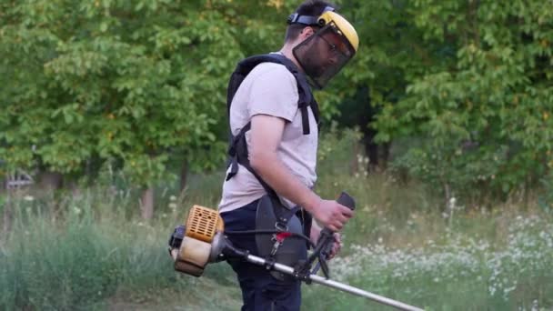 Young Caucasian Man Farmer Gardener Standing Field String Trimmer Petrol — Stock Video