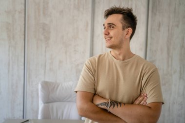 One man adult caucasian male standing in front of table desk at work in the office or work from home wear shirt looking confident casual happy smile copy space real people freelance work