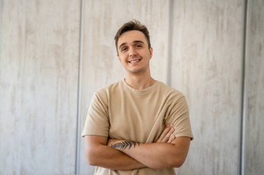 One man adult caucasian male standing in front of table desk at work in the office or work from home wear shirt looking confident casual happy smile copy space real people freelance work