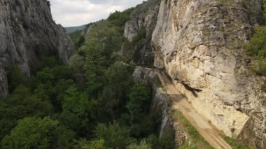 Yukarıdan insansız hava aracı videosu kırsal kesimde bisiklet süren bir grup insanı takip ediyor. Vadi yaz günü eğlence etkinliği kavramı boyunca kırsal arazi yolunda bisiklet sürüyor.