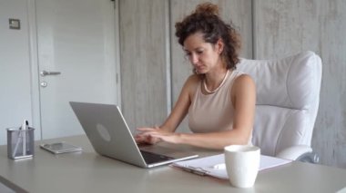 Genç bir beyaz kadın, beyaz kadın girişimci ya da iş kadını. Küçük işletme yöneticisi, ofisteki dizüstü bilgisayarının fotokopi odasında çalışıyor. Gerçek insanlar internetten e-postaları kontrol ediyor.