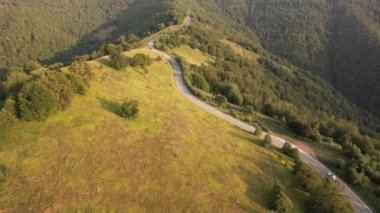 Sırbistan 'ın Knjazevac kenti yakınlarındaki sonbahar veya yaz günlerinde araba kullanan otomobilin yol üzerindeki yüksek açılı hava aracı görüntüsü konsepti