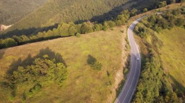 Sırbistan 'ın Knjazevac kenti yakınlarındaki sonbahar veya yaz günlerinde araba kullanan otomobilin yol üzerindeki yüksek açılı hava aracı görüntüsü konsepti