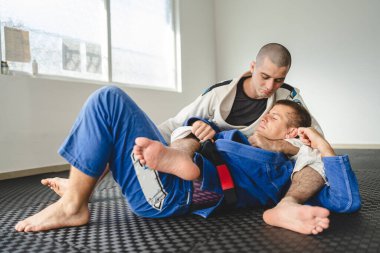Brezilyalı jiu jitsu bjj eğitimi ya da iki sporcuyu serbest bırakmak tatami minderlerinde dövüş sanatları tekniği. Kimono gi siyah kuşak eğitmeni.