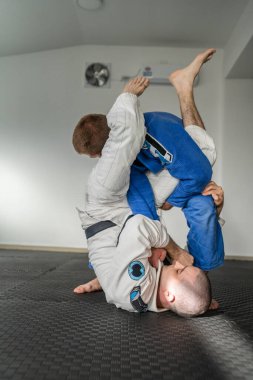 Brezilya jiu jitsu bjj eğitimi ya da iki sporcuyu serbest bırakmak tatami minderlerinde dövüş sanatları tekniği. Kimono gi siyah kuşak eğitmeni.