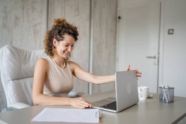 Genç bir kadın, beyaz kadın, ofise geri dönüp dizüstü bilgisayar ve gülümseyen girişimci, modern iş kadını konsepti üzerinde çalışıyor.