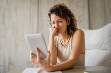 Bir genç iş kadını, modern girişimci iş konsepti üzerinde çalışırken dijital tablet kullanarak ofise geri dönen beyaz bir kadın.