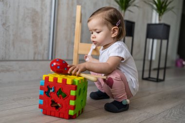 Küçük beyaz bir kız. Küçük beyaz bir çocuk. Evinde yerde plastik tuğla oyuncakla oynuyor.