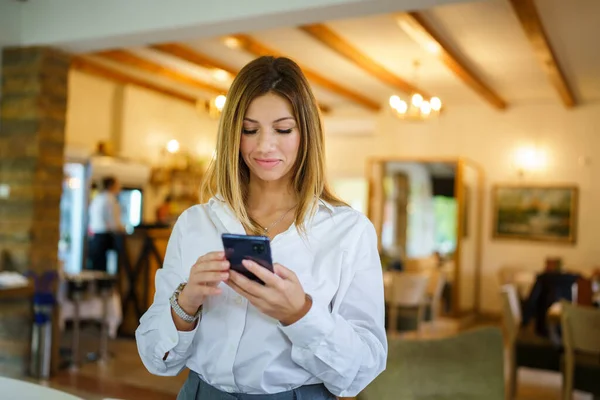 Bir Kadın Kafkasyalı Kadını Restoranda Duruyor Cep Telefonuna Bakıyor Girişimci — Stok fotoğraf