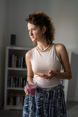 Kafkas kadın girişimci yönetici ya da sekreter ofisinin önünde duruyor. Smoothie 'nin mesajları kontrol etmek için cep telefonu kullandığından emin.